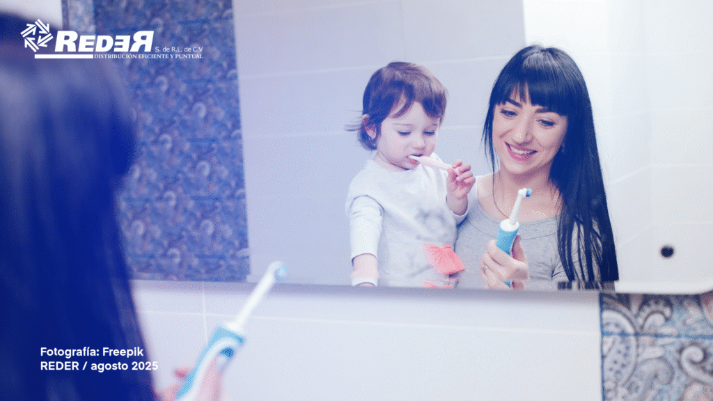 Niño pequeño cepillándose los dientes con ayuda de un adulto