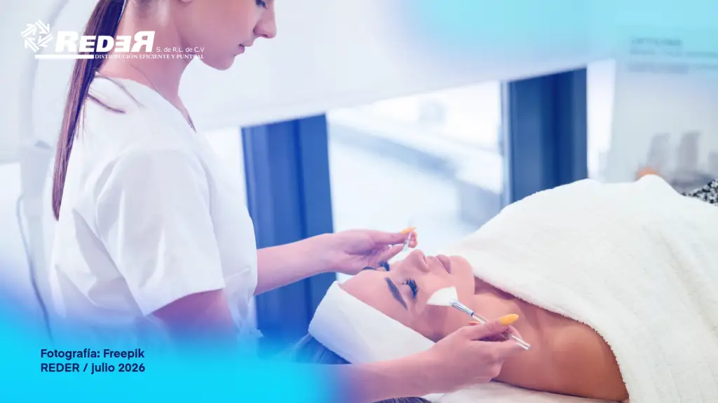 Profesional de estética en spa moderno preparando o aplicando tratamiento facial con vitamina C, con insumos estéticos en primer plano y entorno de spa contemporáneo al fondo.